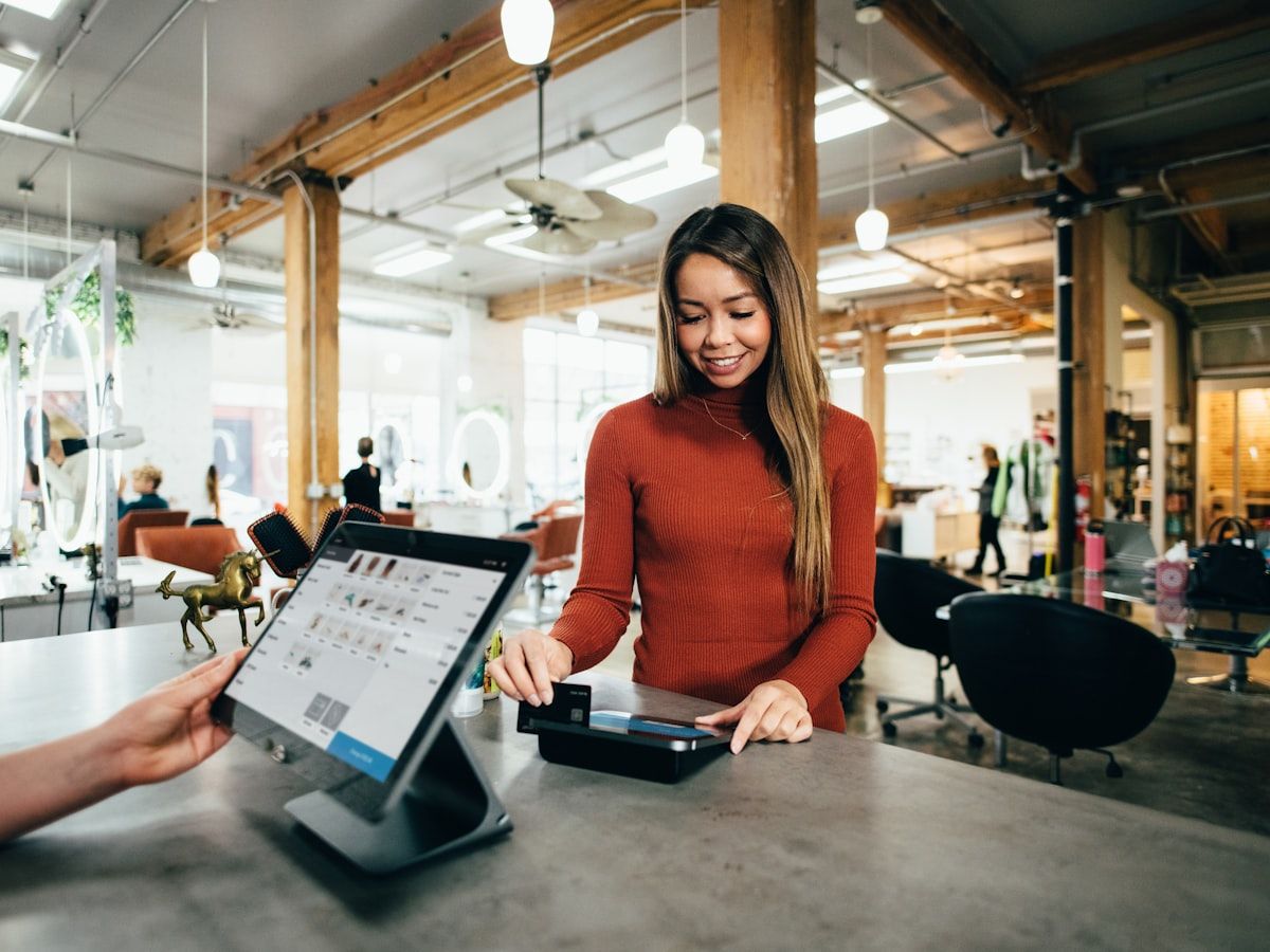 A small business owner taking a card payment at her shop counter